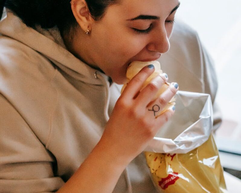 Woman in Hoodie Eating Chips