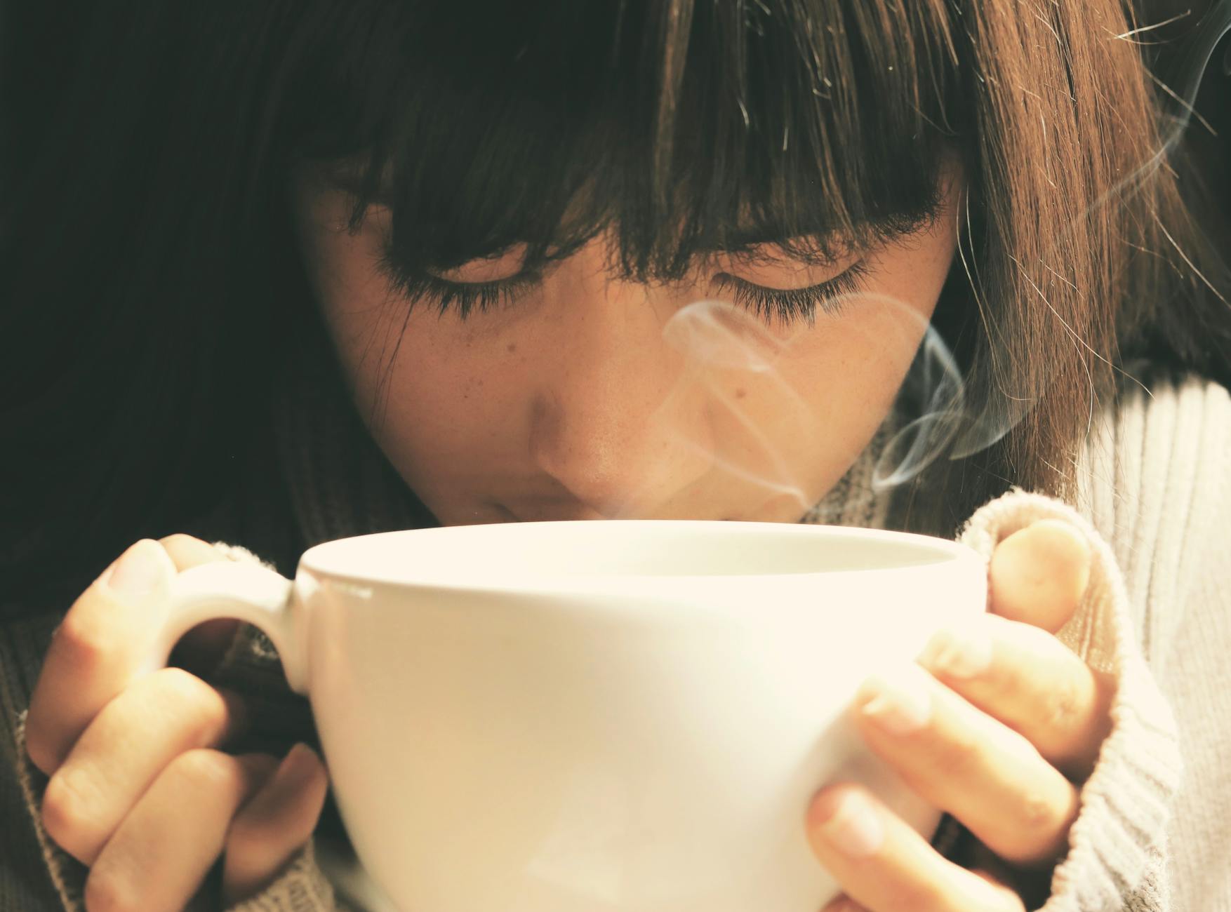 woman holding white cup